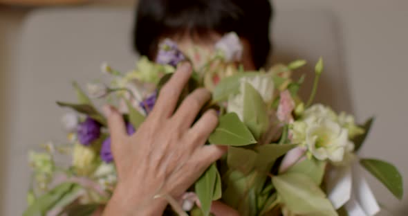 Mature Retired Woman Received Bouquet of Flowers Enjoying Them Inhales Aromas alt
