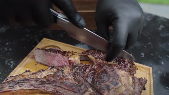 Waiter in Gloves Cuts a Juicy Steak