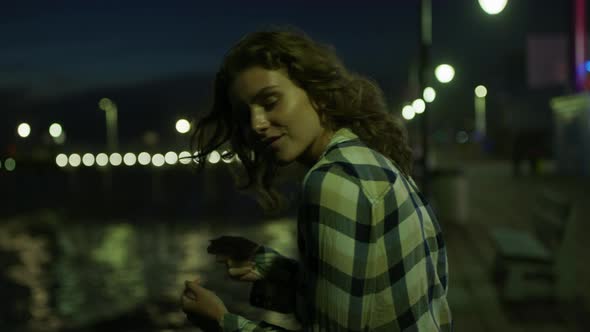 Girl relaxing on Santa Monica Pier, at night alt