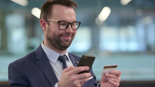 Middle Aged Businessman with Online Shopping Success on Smartphone alt