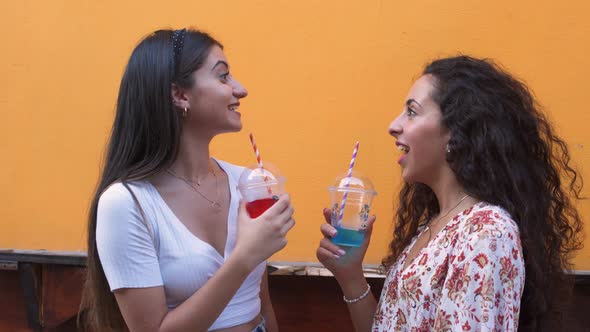 Happy Multiethnic Teenage Girls Drinking Slush Outdoors and Laughing