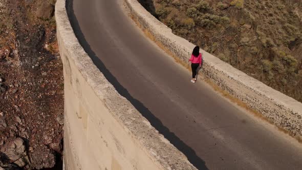 Aerial of a woman hiking across the Salmon Falls Dam in Southern Idaho alt