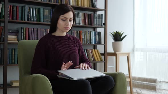 Casual Sitting Woman Closing Laptop and Leaving Sofa in Office alt