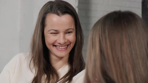 Close Up of a Mother and Daughter Sitting on Sofa at Their Home and Talking alt