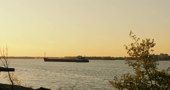 Empty barge waiting for loading. A moored ship with container cranes in an industrial port.  alt