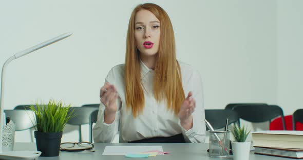 Young Redhead Woman in Glasses Has Online Business Conference Call alt