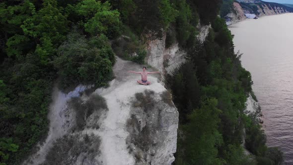 Young Shirtless Man Meditating on a Cliff at Early Morning  Looking in the Camera alt