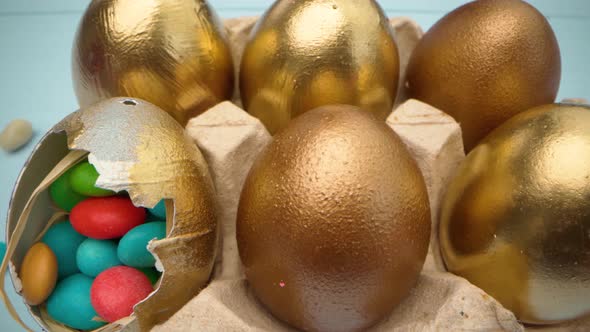 Golden Decorative Easter Eggs Filled with Colorful Candies on Wooden Table Close Up