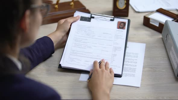 Employee Looking Through Visa Application and Signing Deportation Document
