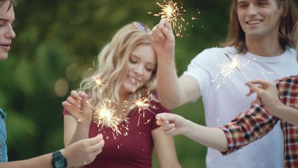 Happy Friends With Sparklers Having Fun Outdoors alt