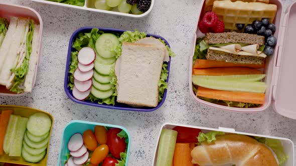 Shot of School Lunchboxes with Various Healthy Nutritious Meals on Stone Background