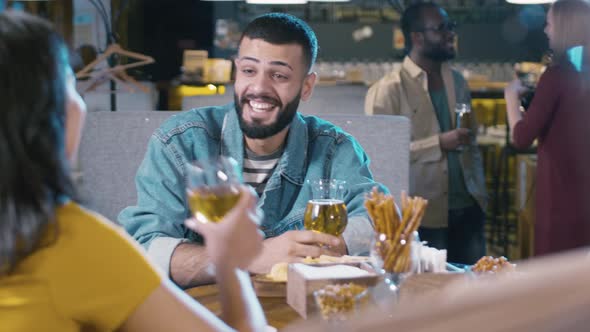 Laughing Arabian man sitting in bar with woman