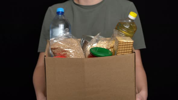 Volunteer Putting Food in a Donation Box. Charity Concept alt