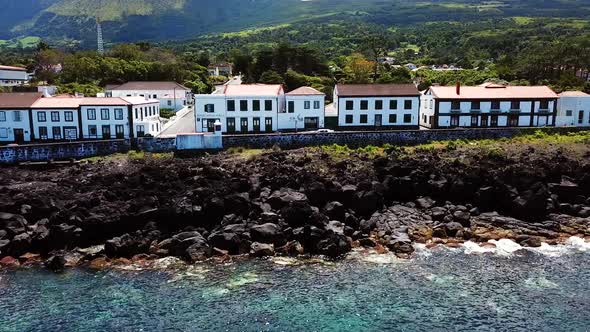 Sliding Shot of the rocky bluish coast and buildings of Sao Roque do Pico in Pico Island, Azores. Po alt
