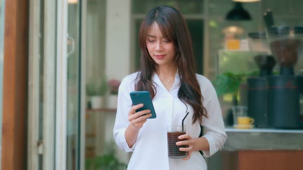 Beautiful Young Asian Woman Using Smartphone in Coffee Shop Happy Smiling alt