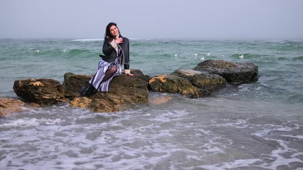 Woman at the Seaside Standing on Beach Looking Out Over Ocean Watching Seagulls alt