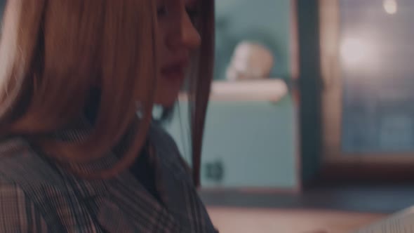 Young Attractive Caucasian Woman Flips Through the Pages and Gets Acquainted with the Contents of alt