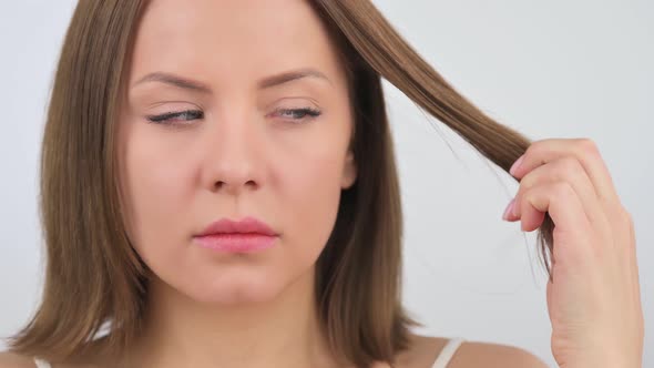 Young Woman Unhappy About Her Brittle Dry Hair and Splitting Ends