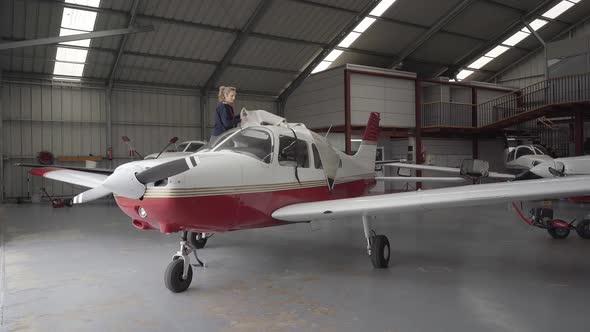 Pilot discovering light aircraft with protective cover in hangar alt