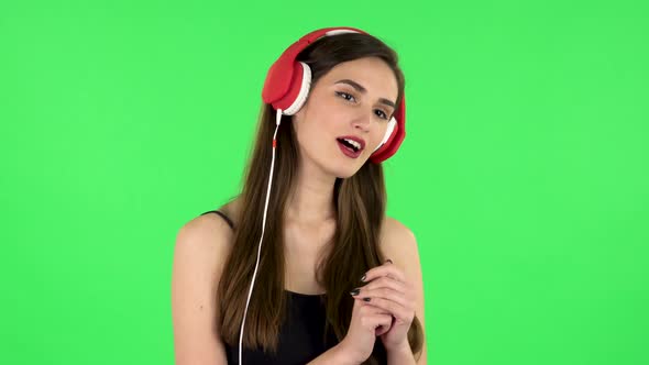 Cheerful Girl Dancing and Enjoys Music in Big Red Headphones alt