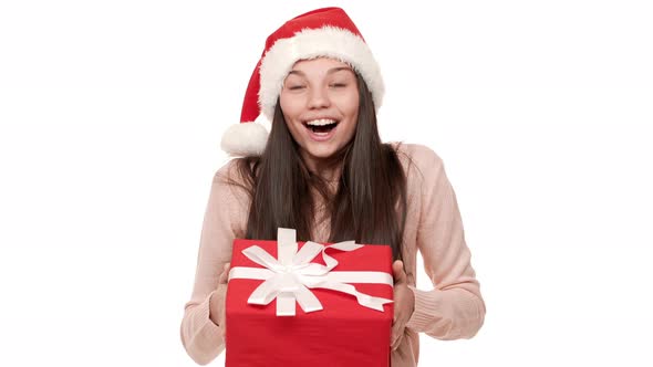 Portrait of Excited Female with Very Long Hair Wearing Santa Claus Red Hat Being Shocked to Receive alt