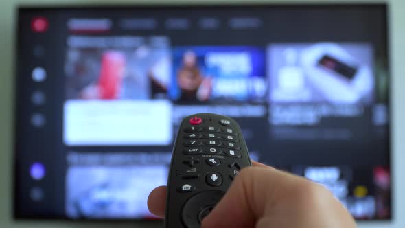 Male Hand Holding the TV Remote Control Channel Surfing alt