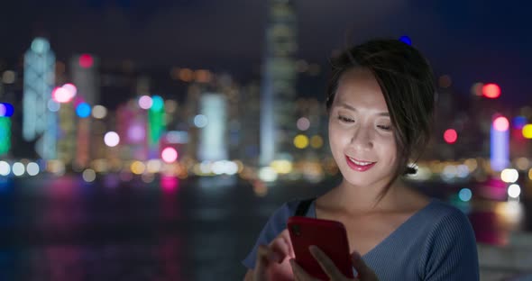 Woman use of smart phone in city at night alt