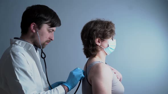 Male Doctor Pulmonologist Makes a Medical Examination of a Female Patient with a Coronavirus and Has alt