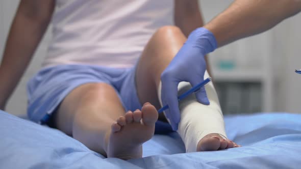 Doctor Checking Patient Leg in Elastic Bandage, Writing Examination Result