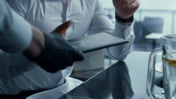 Unknown Man Reading Restaurant Bill at Business Lunch alt