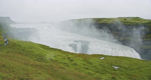 Gullfoss Waterfall and Silhouette of Tourist Standing on View Platform alt