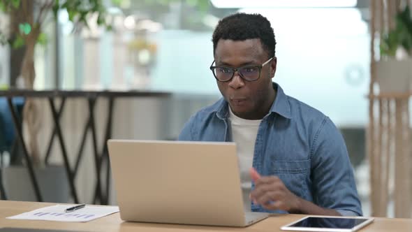 Successful Young African Man Celebrating on Laptop alt