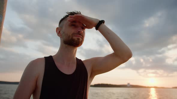A Man Looks Into the Distance of the Lake While Walking on a Boat