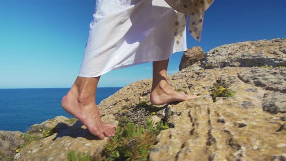 Bare Female Legs Walking Feets on Rocky Terrain alt