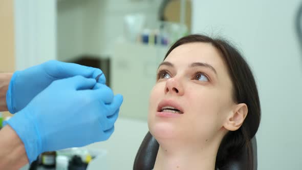 Orthodontist Doctor Checks the Closing of the Woman Teeth Using Carbon Paper