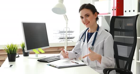 Female Doctor Showing Fingers at Documents and Looking at Camera
