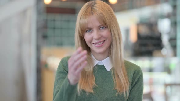 Portrait of Young Woman Pointing at the Camera and Inviting alt