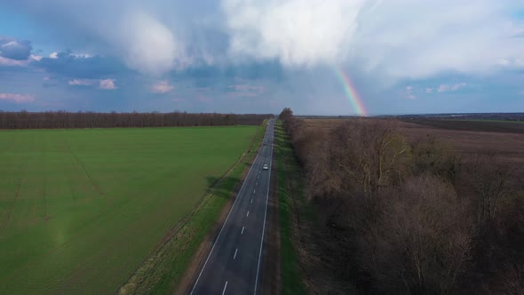 Sun-Shower With Rainbow Over the Highway alt