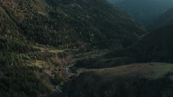 Dusk in the mountain valley, drone flies over river, mystical landscape with deep autumn forest