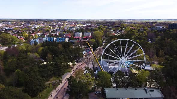 White Ferris wheel under construction with cityscape of Palanga, aerial view alt