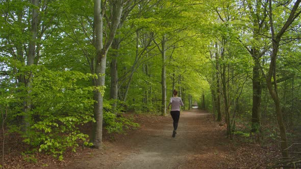 Woman Running in Forest alt