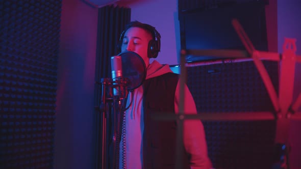 A Man in Headphones Rapping Through the Pop-filter in the Microphone - Recording His Track alt