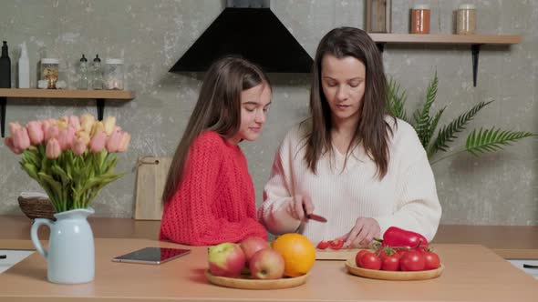 Mother Talks to Her Daughter While She Prepares the Vegetable Salad alt