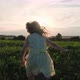 Happy little five-year-old girl runs across the green grass in a meadow toward the sunset. - VideoHive Item for Sale
