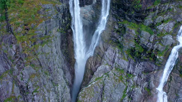 Stunning high twin waterfall flowing from a tall mountain - Pan view alt
