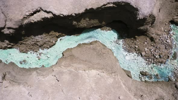 Dead Sea Hot Springs dramatic aerial top down shot following desert canyon landscape with crystal cl alt