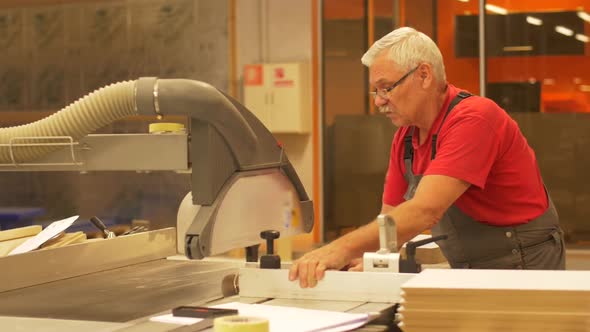 Carpenter with Panel Saw and Mdf Board at Factory  alt