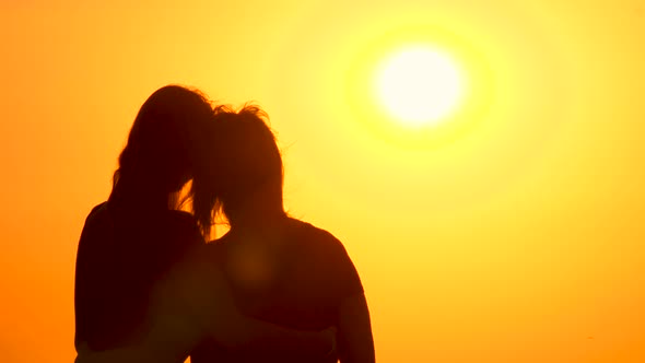 Grown Up Daughter Hugging Mother While Watching Sunrise. Cinematic Background of Sunrise with Two