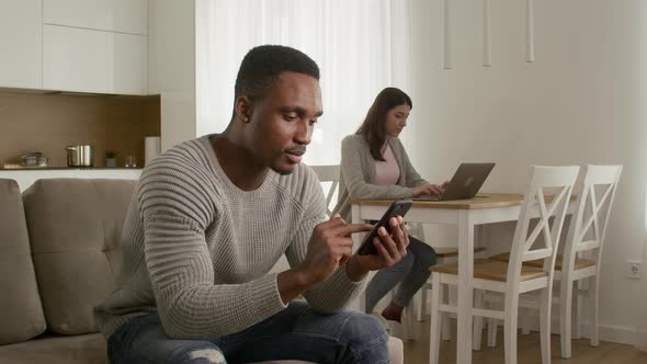 Young Adult Couple Couple Browsing the Web and Interact with Each Other While Sitting at Home alt