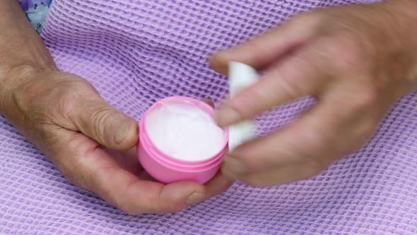 Old Lady Apply White Moisturizer Cream to Her Hand. Senior Women Hand Skincare